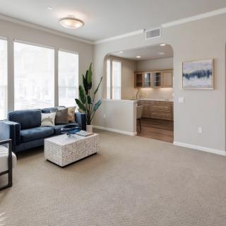 A modern living room with a comfortable sofa, coffee table, and large windows letting in natural light.