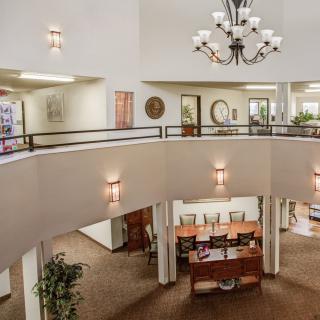 Spacious lobby with a chandelier and upper balcony overlooking the reception area.