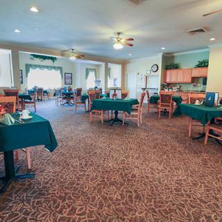 A spacious dining area with neatly arranged tables and chairs, featuring a warm and inviting decor.