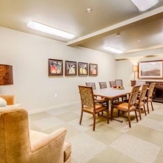 A well-lit meeting room featuring a large table surrounded by chairs and artwork on the walls.