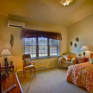 A cozy bedroom with comfortable furnishings and warm lighting.
