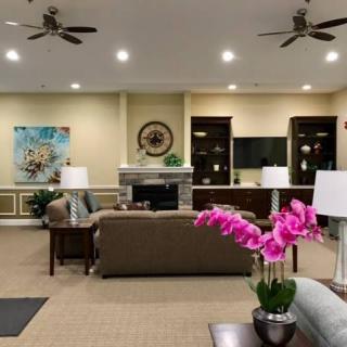 A modern living room with comfortable seating, a fireplace, and elegant floral decorations.