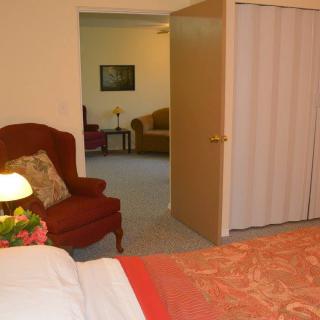 A cozy bedroom with a view into an adjoining living room through an open door.