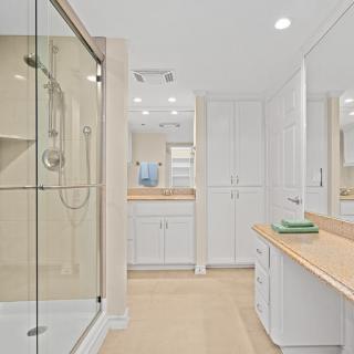 A sleek and modern bathroom featuring clean lines, a glass shower, and ample storage.