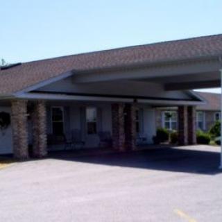 A building entrance with a covered driveway supported by stone columns.