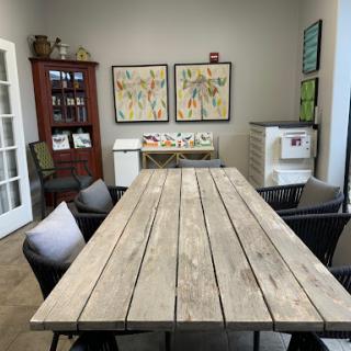 A cozy meeting room featuring a large wooden table, comfortable chairs, and colorful artwork on the walls.