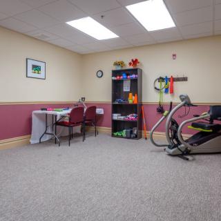 A small indoor exercise and therapy room equipped with various fitness tools and furniture.
