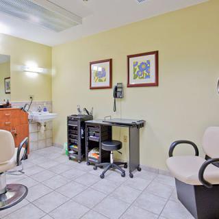 A tidy and well-equipped hair salon with chairs, a sink, and mirrors.