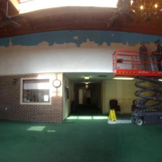 An indoor hallway under renovation, with scaffolding equipment present.