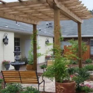 A cozy backyard with a wooden pergola and garden seating area.