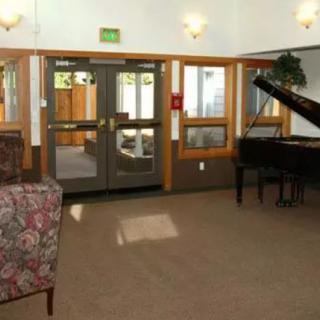 A cozy lobby area with a grand piano and seating.