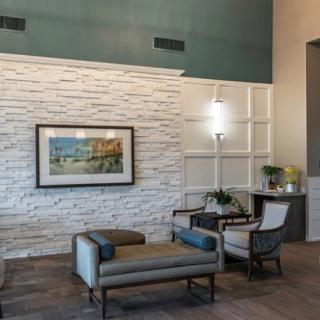 A modern lobby with comfortable seating and a decorative painting on the wall.