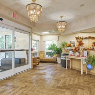 A warm and inviting lobby featuring elegant chandeliers and lush greenery.