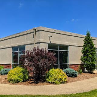 A well-maintained commercial building with vibrant landscaping under a clear blue sky.