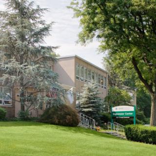 A serene view of a school building surrounded by greenery.