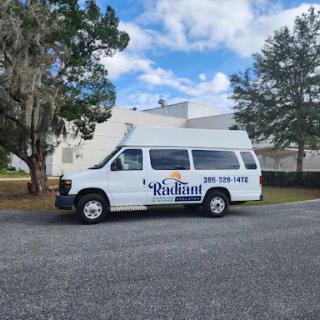 A white van parked on the roadside, likely used for transportation services.