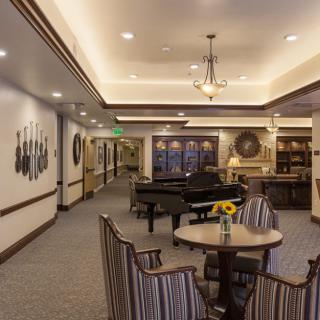 A cozy lounge area featuring a piano, comfortable seating, and elegant decor.