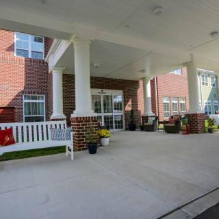 A welcoming entrance with a covered walkway and seating area.
