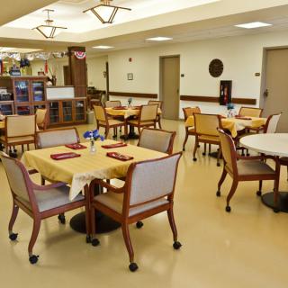 An empty dining area with neatly arranged tables and chairs in a well-lit indoor setting.