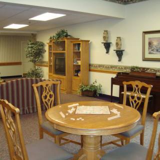 A cozy living room with a dining table, chairs, and decorative elements.