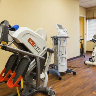A therapy or fitness room equipped with exercise machines and other gym equipment.