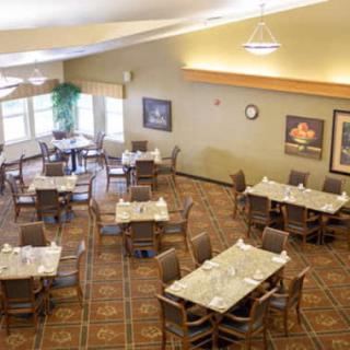 An empty dining room with neatly arranged tables and chairs.