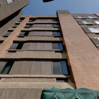 A low-angle view of a modern building facade against a clear sky.