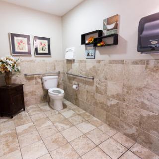 A clean and well-designed bathroom with tiled floors and decorative elements.