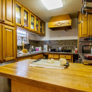 A cozy kitchen with wooden cabinets and a countertop featuring dough ready for baking.
