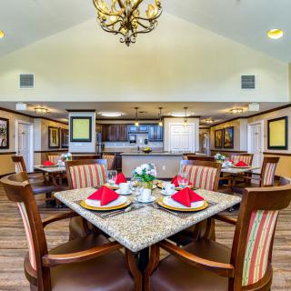 A well-decorated dining room with elegant table settings and a chandelier.