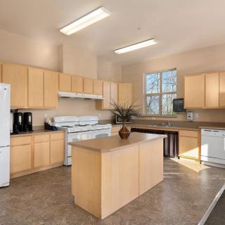 A modern and spacious kitchen featuring wood cabinets and a central island.