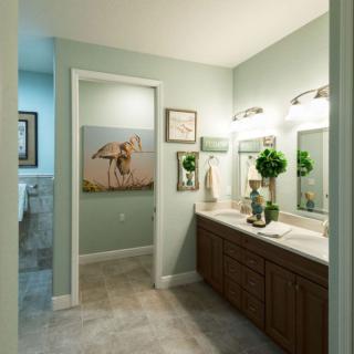 A modern bathroom with dual sinks, decorative lighting, and elegant wall art.