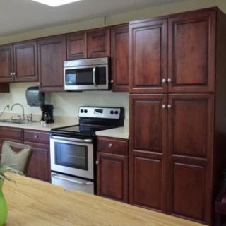 A modern kitchen featuring wooden cabinets and stainless steel appliances.