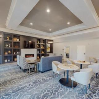 A modern living room featuring comfortable seating, a fireplace, and a built-in bookshelf.