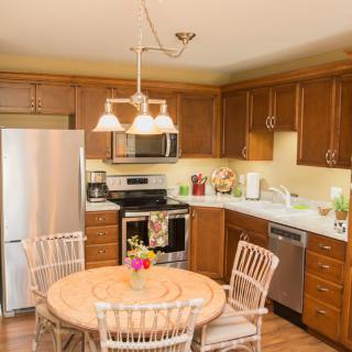 A warm and inviting kitchen with wooden cabinets, stainless steel appliances, and a cozy round dining table.