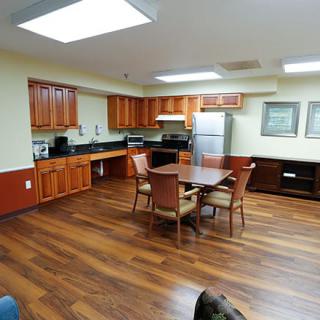 A modern kitchen and dining area with wooden floors and cabinets.