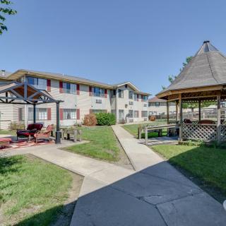A pleasant courtyard with a gazebo and a residential building in the background.