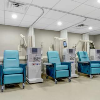 A row of dialysis chairs and machines in a medical facility.
