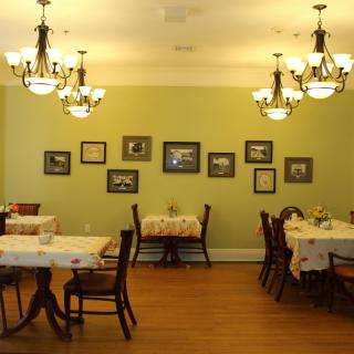 A cozy restaurant dining area with tables, chairs, and elegant chandeliers.