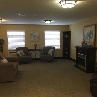 A cozy living room with comfortable seating, a fireplace, and artwork on the wall.