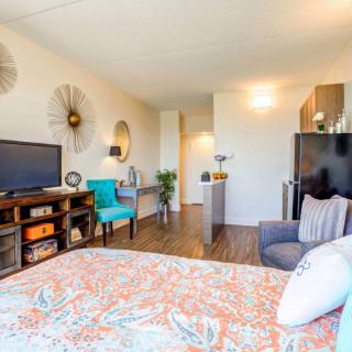 A cozy bedroom with modern decor and a comfortable seating area.