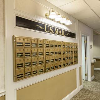A wall of US mailboxes in a building lobby.