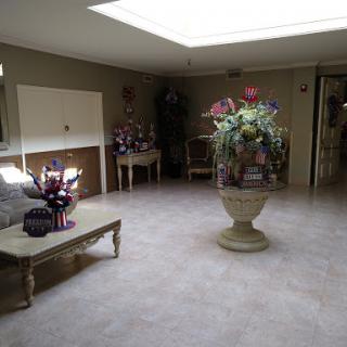 A bright and spacious living room with floral arrangements and a comfortable seating area.