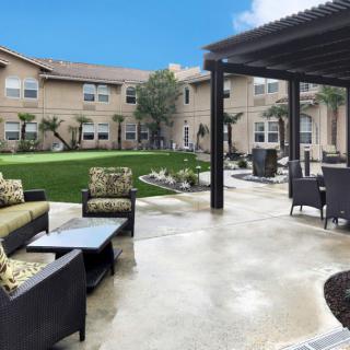 A beautifully landscaped patio area with comfortable seating and a view of the garden.