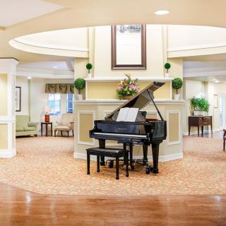 A spacious and elegantly decorated lobby featuring a grand piano.