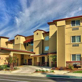 A modern hotel building with a distinctive architectural style under a blue sky.