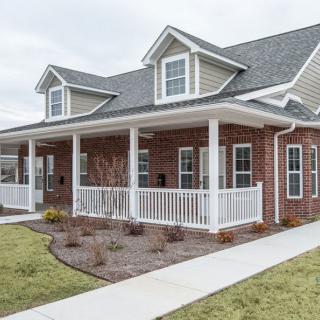 A modern duplex house with a brick exterior and spacious front porch.