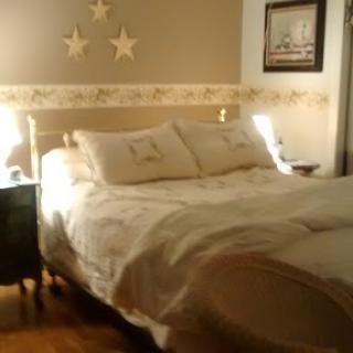 A cozy bedroom setup featuring a neatly made bed with star-themed decorations.