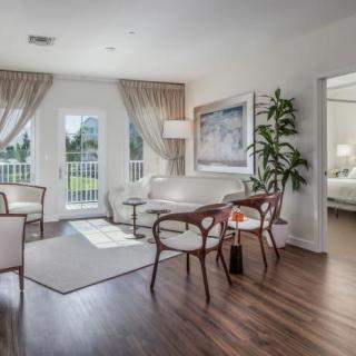 A modern living room with elegant decor, featuring large windows, stylish furniture, and ample natural light.