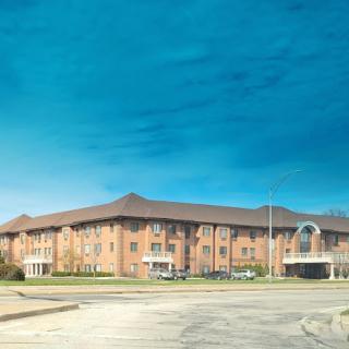 A modern brick hotel building set against a clear blue sky.